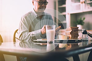 Blurred of asian elderly man preparing healthy food for breakfast with bread and butter,Retirement senior lifestyle living conc