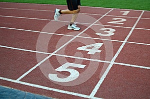 Blurred athlete by a slow camera shutter speed crossing the finish line after sprint track