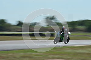 Blurred athletes practicing racing motorcycles on the race track