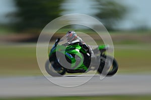 Blurred athletes practicing racing motorcycles on the race track