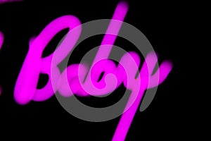 Blurred Baby word in proton purple neon color on black background.