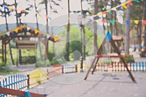 Blurred background of children playground with hanged over party banners.