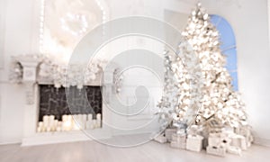 Blurred background christmas interior with New Year tree and artificial fireplace decorated light for holiday, white