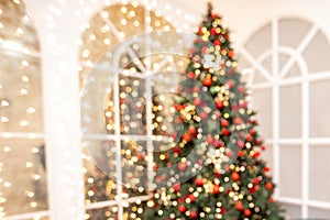 Blurred background Christmas room interior with New Year tree and gifts lights in red, green colors