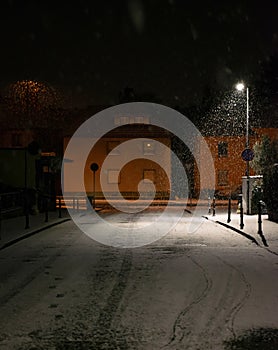 Blurred background. City view, lights, falling snow, night, street, bokeh spots moving cars winter scenery Lantern light