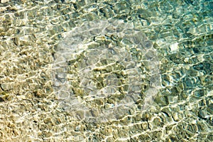 blurred background of clear lake water and pebbles at the bottom