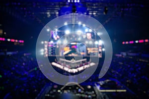 Blurred background of an esports event - Big illuminated main stage of a computer games tournament located on a big