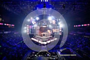 Blurred background of an esports event - Big illuminated main stage of a computer games tournament located on a big