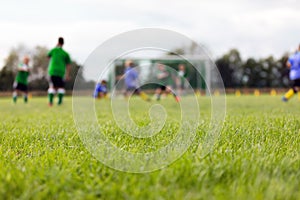 Blurred background of foBlurred background of football field. Boys playing soccer game. Kids in two teams playing tournament match