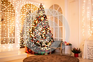 Blurred background illuminations Christmas interior with New Year tree and gifts in red, green colors