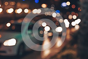 Blurred background with lights of cars in traffic jam. Abstract background with cars on night street.