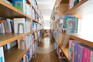 Blurred background of public library, bookshelf with books, diminishing perspective, education concept