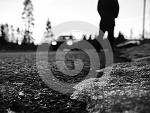 Blurred background. Walk in urban city. Close up view on man`s legs, car headlights