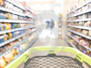 Blurred background with walking through the supermarket with a grocery cart. Blur background of supermarket interior with shopping