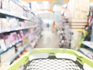 Blurred background with walking through the supermarket with a grocery cart. Blur background of supermarket interior with shopping