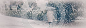 Blurred background, a woman walks with an umbrella down the street in snowy weather. Banner for design