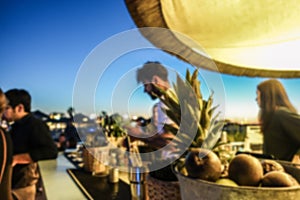 Blurred barman working in chiringuito bar at sunset beach party - Concept of nightlife with cocktails and music entertainment in