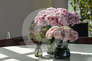 Blurred beautiful pink Chrysanthemum flowers bouquet in glass vase on the table.