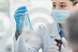 blurred bioengineer in medical mask holding