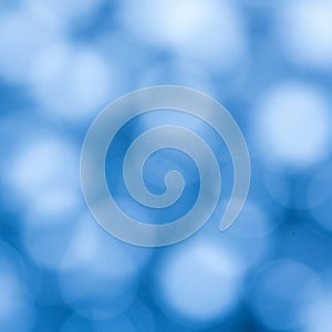 Blurred blue bokeh effect with overlapping circular shapes creating a soft, abstract