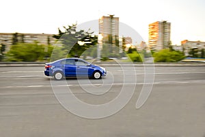Blurred blue sport sedan car fast driving, riding,automobile moving on open empty city street road, highway. Motion blur