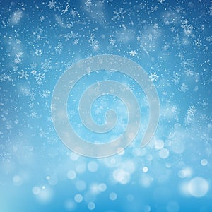 Blurred bokeh light snowflakes on blue background. Christmas and New Year holidays template. Abstract glitter defocused