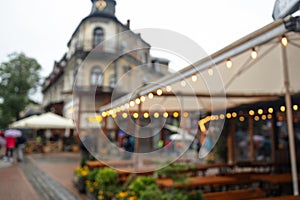 Blurred bokeh light with yellow string lights decor near city restaurant or cafe. Zakopane, Poland