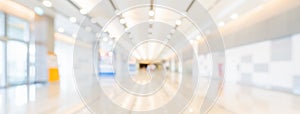 Blurred bokeh panoramic banner background of exhibition hall or convention center hallway. Business trade show event photo