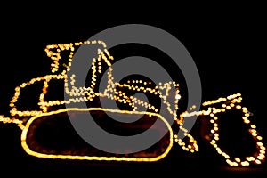 Blurred bulldozer decorated with lights/bokeh lights on a bulldozer