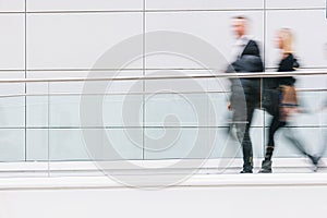 blurred business people walking in a futuristic corridor, including Copy space