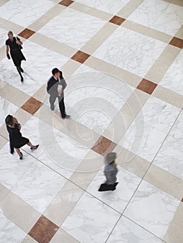 Blurred Business People Walking On Tiled Floor