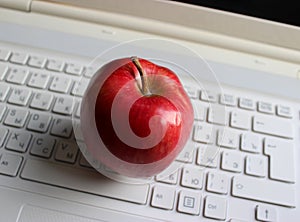 Blurred Buttons Of White Keyboard With Juicy Red Apple Fruit On It