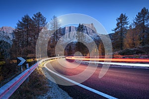 Blurred car headlights on winding road in mountains at night