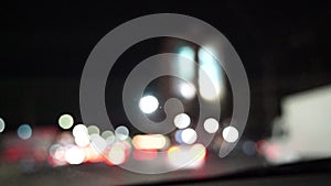 Blurred car lights bokeh in the evening city. Defocused headlights and street lighting at night. Moving bokeh circles of
