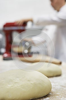 Blurred Chef Using Dough Mixer In Kitchen