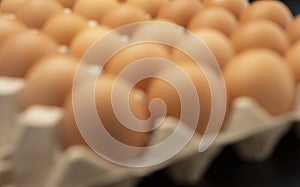 Blurred of chicken eggs in a row on black background