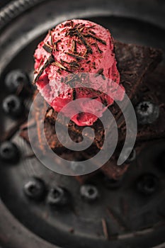 Blurred chocolate brownie with blueberry and ice cream on the vintage plate vertical