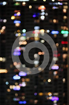 Blurred city block apartment colored party lights bokeh during holiday season vertical background