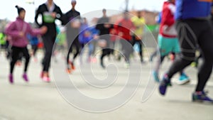 Blurred colorful crowd of people running at city marathon on asphalt road