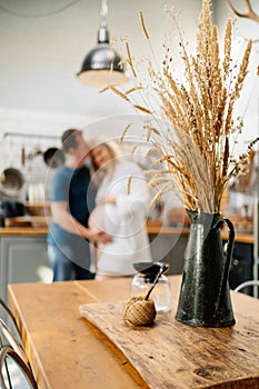 Blurred couple hugs in kitchen. happy pregnancy