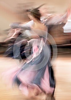 Blurred dancing couple in ballroom photo