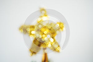 Blurred defocus with Bokeh of golden star of Christmas tree decoration on white background