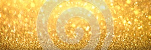 Blurred defocused bokeh banner with Christmas lights and golden glitter sparkles