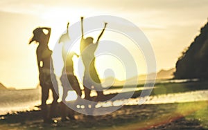 Blurred defocused silhouette of women travelers at sunset - Travel wanderlust concept with young girlfriends partying and dancing