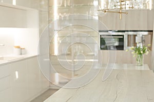 Blurred empty kitchen with wooden table top with white modern interior background