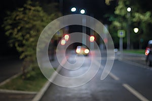 Blurred empty night street, taxi standing by traffic lights, defocused picture