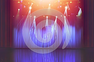 Blurred empty theatre stage with fun colourful spotlights, abstract image of concert lighting  illumination background