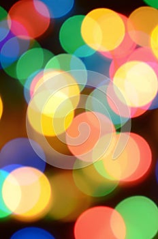 Blurred festive colorful lights over black useful as background. All main colors included. Red, yellow, green and blue