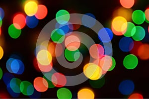 Blurred festive colorful lights over black useful as background. All main colors included. Red, yellow, green and blue