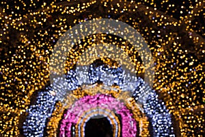 Blurred garland as arc or semicircle. City night light blur bokeh, defocused background. Holiday abstract pattern